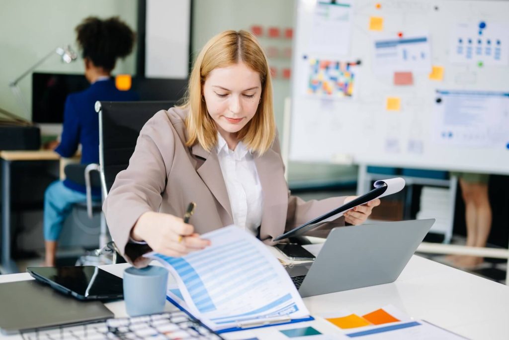 businesswoman holding financial charts inside a office