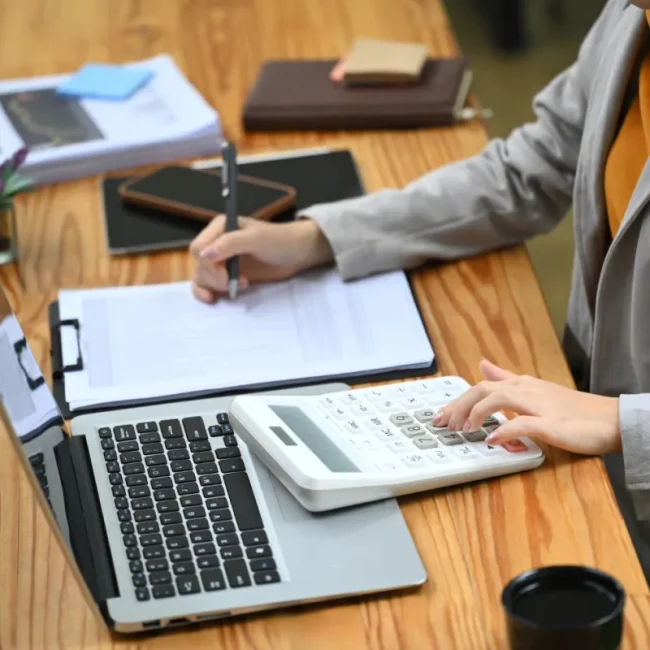 Professionals examining financial reports and data charts together during a business review meeting.