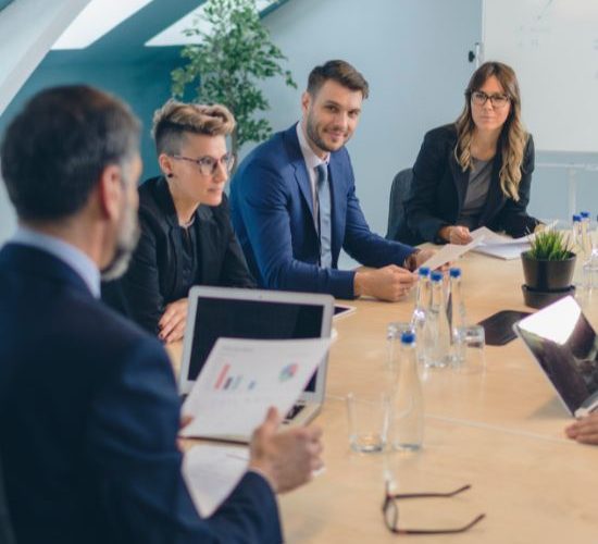 Business professionals discussing reports during corporate meeting