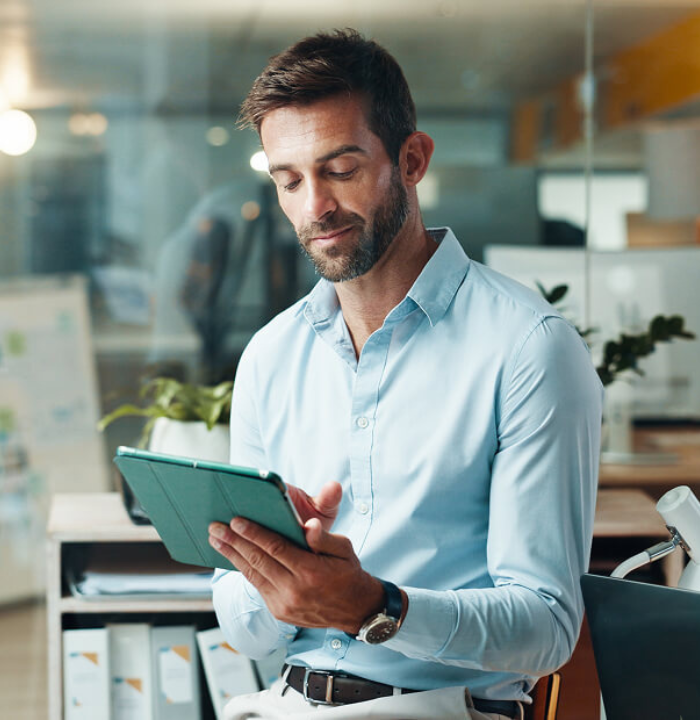 Business professional using tablet to review data in modern office