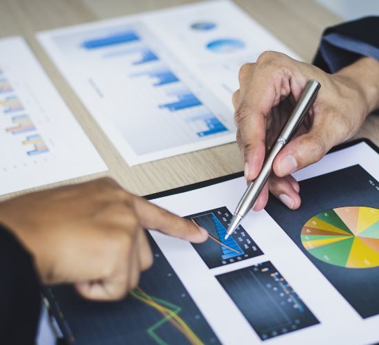 Administrative task underway with papers, pen, and digital device on desk.